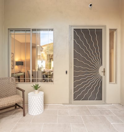 Covered Scottsdale front patio with seating area and decorative security door, offering charm and privacy.