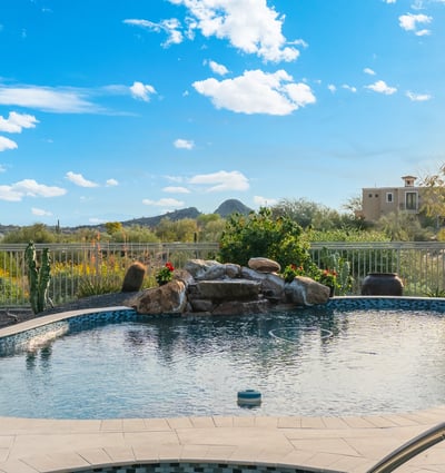 Scottsdale backyard with sparkling pool, water feature, and desert views, perfect for relaxing or entertaining outdoors.