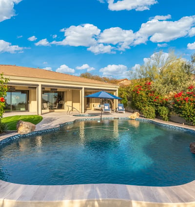 Scottsdale outdoor living area with pool, covered patio, and landscaped yard, offering comfortable indoor-outdoor flow.