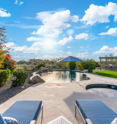 Scottsdale outdoor kitchen with pergola, built-in grill, and bar seating, creating a perfect space for entertaining guests.