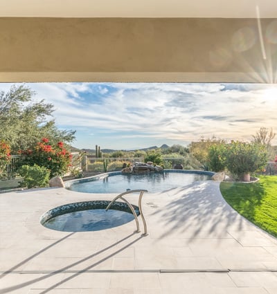 Scottsdale covered patio overlooking pool and spa with landscaped surroundings and mountain views, ideal for relaxing outdoors.