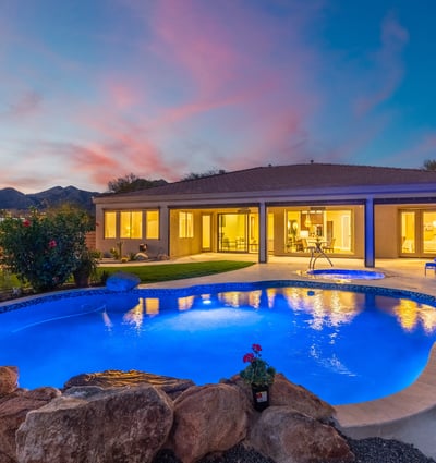 Scottsdale outdoor living with illuminated pool, spa, and covered patio, emphasizing modern updates and resort-style design.
