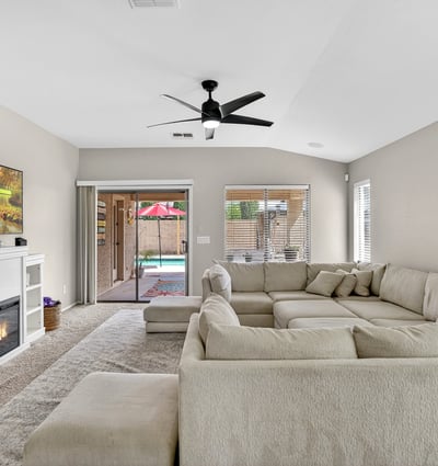 Light-filled living room with fireplace and direct access to the backyard pool area. Open design creates a welcoming space for relaxing or entertaining in this Casa Grande home.
