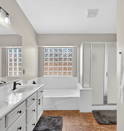 Bright primary bathroom with dual vanities, soaking tub, and walk-in shower. Functional layout offers everyday comfort in this Casa Grande property.