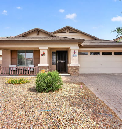 Attractive exterior with covered porch, desert landscaping, and attached garage. Clean curb appeal defines this Casa Grande property.