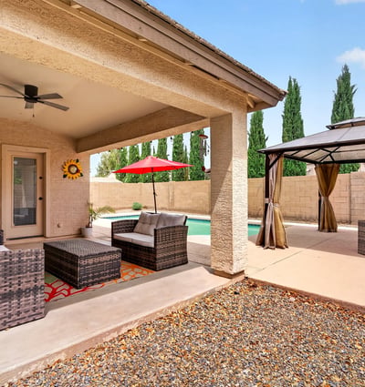Covered patio with seating and views of the pool and pergola area. Designed for entertaining and enjoying Arizona-style outdoor living in Casa Grande.