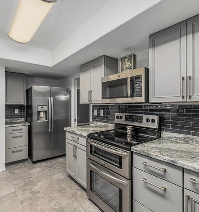 Kitchen featuring stainless steel appliances, updated cabinets, and stylish backsplash. This Sun City home showcases contemporary upgrades and efficient design.