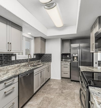 Kitchen with built-in storage, updated counters, and stainless steel appliances. This Sun City home highlights modern updates and organized space.