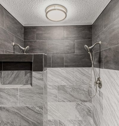 Walk-in shower featuring custom tile surround and built-in shelving. This Sun City home highlights upgraded bathrooms and contemporary style.