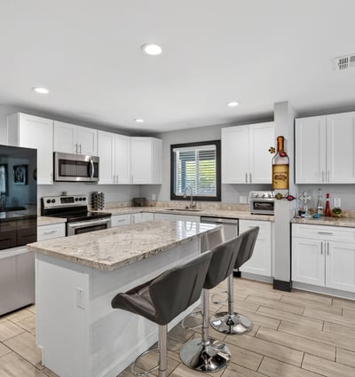 Renovated kitchen featuring granite countertops, stainless appliances, and a large island, designed for both everyday use and entertaining.