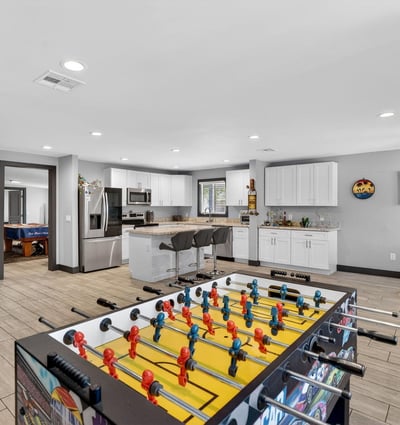 Versatile space combining game area and kitchen access, ideal for entertaining and flexible living arrangements.