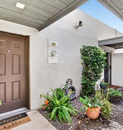 Covered front entry with desert landscaping and greenery creates a warm welcome to this Scottsdale townhome with added privacy and charm.