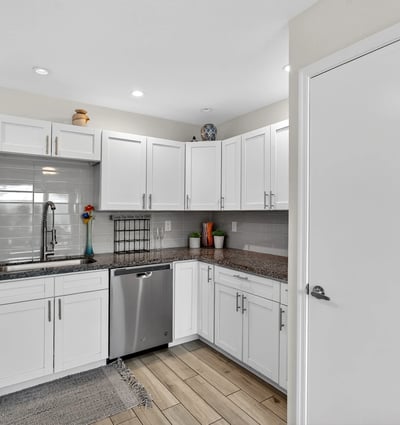 Stylish Scottsdale kitchen featuring white cabinetry, tile backsplash, and functional layout designed for efficient meal prep and storage.