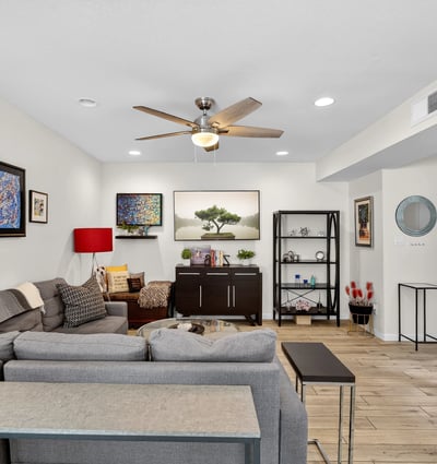 Inviting Scottsdale living space with staircase feature, updated flooring, and open flow connecting living, dining, and kitchen areas.