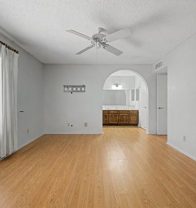 Bright and welcoming, this primary bedroom features a generous footprint and neutral finishes. Large windows and durable flooring contribute to the room's comfortable and inviting feel.