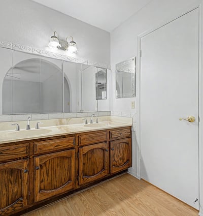 The bathroom's dual-sink vanity provides extensive storage, generous countertop space, and large mirrors for added convenience. Thoughtful design elements support both functionality and everyday comfort.