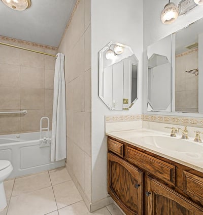 Featuring a large vanity, attractive tilework, and a tub-shower combination, this guest bathroom balances style and functionality. Ample storage and thoughtful design make daily routines convenient and comfortable.