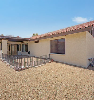 The expansive backyard showcases easy-care desert landscaping and open outdoor space. Thoughtfully designed for minimal maintenance, it offers privacy and room to enjoy Arizona's outdoor lifestyle.