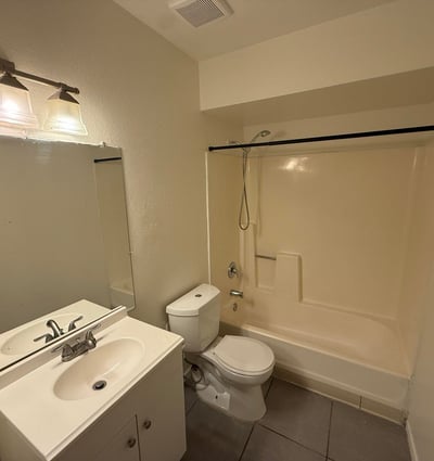 Full bathroom equipped with a modern vanity, updated lighting fixture, and tub-shower combination. Neutral finishes and practical design elements make this space ideal for everyday use.