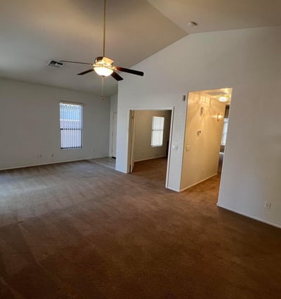 Bright and spacious living room offering vaulted ceilings, multiple windows, and flexible furniture placement options. The open layout enhances comfort while maximizing usable living space.