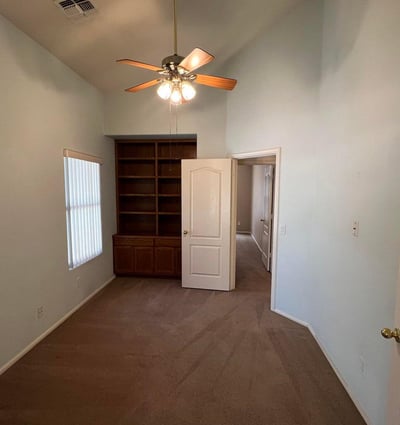 Flexible den enhanced by custom built-in shelving and vaulted ceilings. Ideal as a home office, study area, reading room, or hobby space while adding versatility to the home's layout.