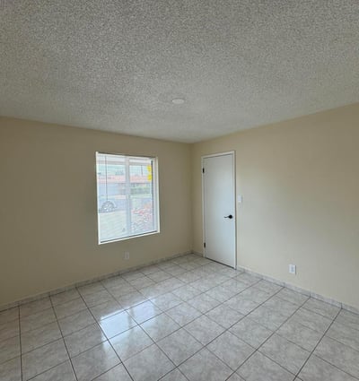 Bright bedroom featuring a modern ceiling fan, neutral color palette, and easy-care tile flooring. The flexible floor plan accommodates a variety of lifestyle needs.
