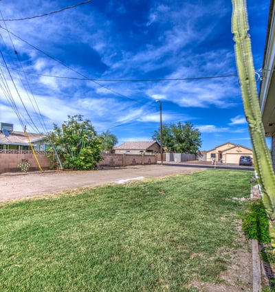 A generous backyard with grassy space and mature landscaping provides plenty of room for outdoor entertaining, pets, gardening, or future backyard enhancements at this Buckeye home.