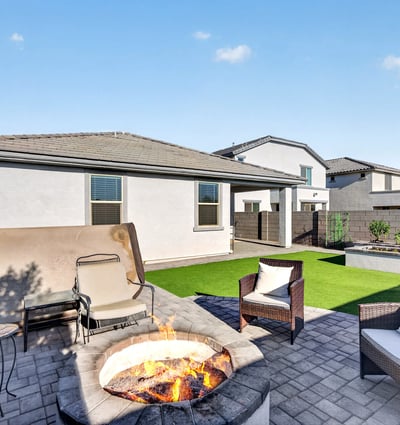 Entertain family and friends around the custom fire pit while enjoying professionally landscaped outdoor living spaces, artificial grass, and inviting patio seating areas.