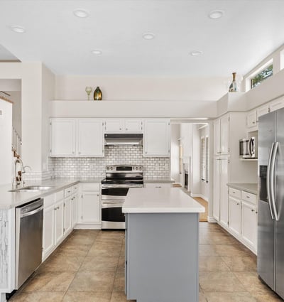 This updated kitchen showcases newer cabinetry, modern countertops, stainless steel appliances, recessed lighting, and a spacious center island. The open layout makes meal preparation and entertaining effortless in this Chandler home.