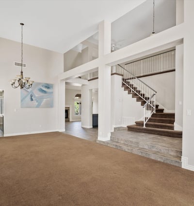 Enjoy an expansive open living space featuring soaring ceilings, a dramatic staircase, and abundant natural light. The thoughtful layout creates an inviting atmosphere that flows effortlessly into the adjoining living areas, making it ideal for entertaining or relaxing.