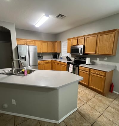 Spacious kitchen showcases oak cabinets, stainless steel appliances, a center island with breakfast bar, and an open layout ideal for cooking, entertaining, and gathering with family.
