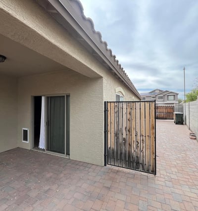 Covered patio opens to an extended paved side yard leading directly to the RV gate, providing excellent accessibility, additional storage options, and low-maintenance outdoor living.