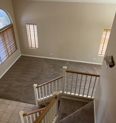 From the upper level, enjoy a striking view of the dramatic foyer featuring vaulted ceilings, expansive windows, and a spacious open-concept design.