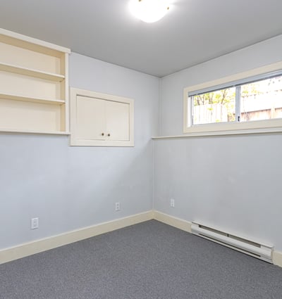 Bright, versatile room with built-in shelving, offering potential for a home office or creative space.