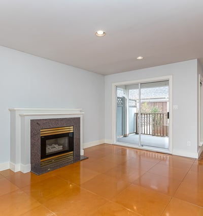 Bright and open living space featuring a cozy fireplace and access to a private outdoor balcony.