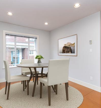 Bright and airy dining area featuring a modern table set and large windows for natural light.