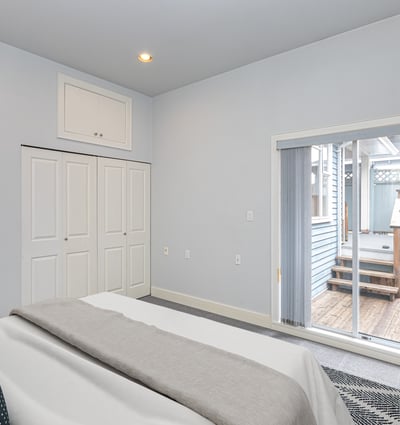 Bright bedroom features sliding doors leading to a private outdoor deck, perfect for relaxation and enjoyment.