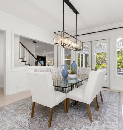 Bright dining area featuring large windows, modern lighting, and access to an outdoor patio space.