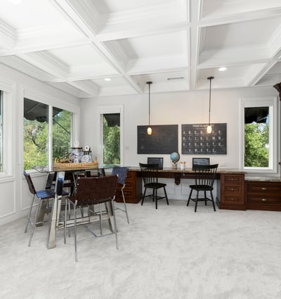 Loft/Entertaining Space featuring large windows, custom cabinetry, and versatile workspace for productivity.