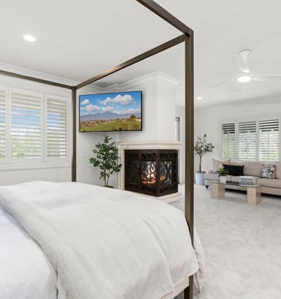 Primary Bedroom -Spacious bedroom with a cozy fireplace, adjacent sitting area, and abundant natural light throughout. (TV Included)