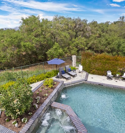 Primary Bedroom Balcony- Discover a private oasis with a refreshing pool, lush greenery, and inviting outdoor seating for relaxation.