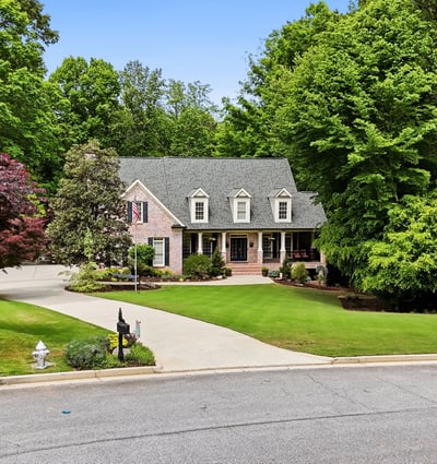 Beautifully landscaped home nestled on a quiet cul-de-sac, surrounded by mature trees and vibrant foliage.