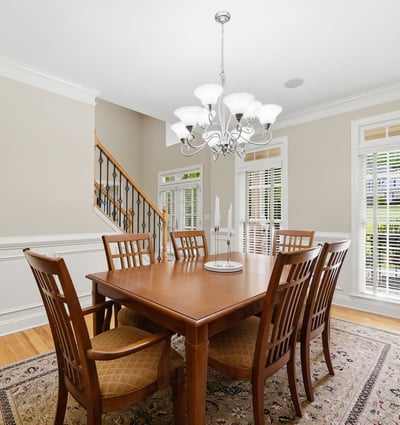 Bright dining room with tall windows, transom detail, plantation shutters, and beautiful trim work a polished space that feels connected to the main level while still having its own sense of occasion.