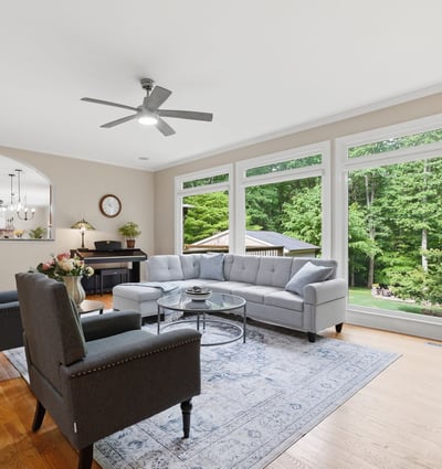 Spacious living room with expansive windows offering ample natural light and a picturesque view of the backyard.