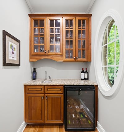 Perfect for entertaining, this cozy wine nook features stylish cabinetry and a compact fridge for easy access.