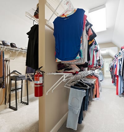 Spacious walk-in closet featuring abundant shelving for organized storage and natural light from skylights.