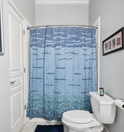 Bright and inviting bathroom featuring a colorful shower curtain and modern fixtures, perfect for daily use.