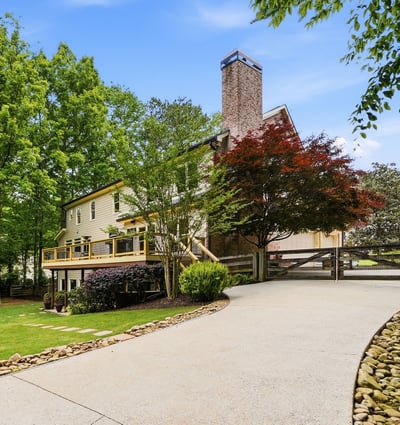 Discover a beautifully landscaped property featuring ample outdoor space and a welcoming driveway leading to the entrance.
