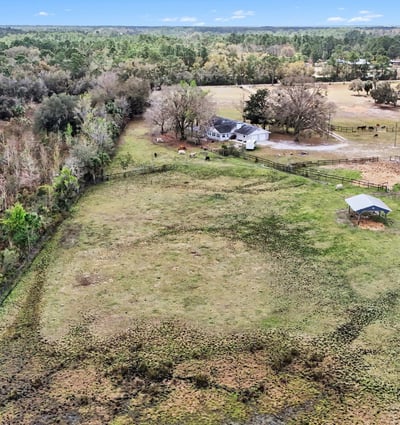 An aerial photo of the pasture and the steel Morton building which can be enclosed to become that shop or RV storage you've dreamed of!