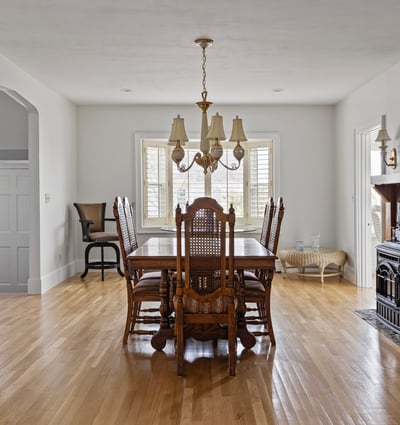 Spacious dining area features ample natural light, classic furnishings, and a cozy fireplace for gatherings.